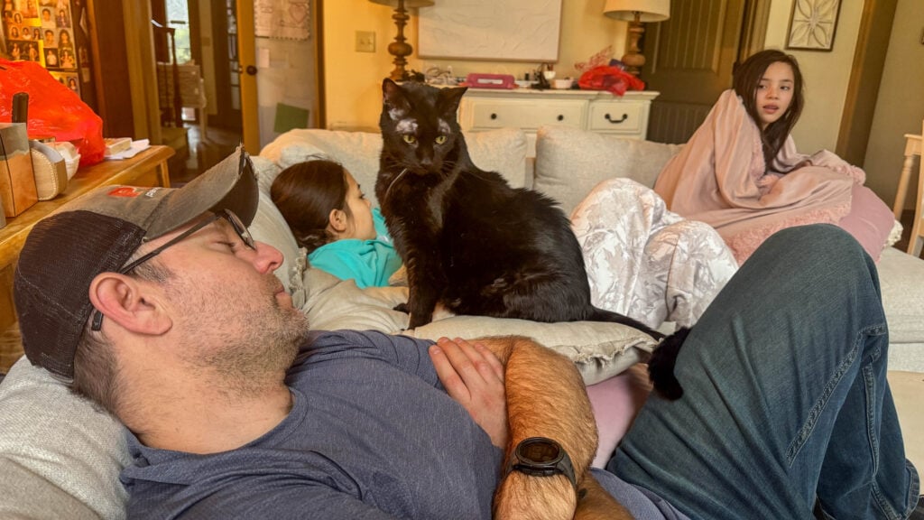 Overhead view of IKEA Finnala sectional with family of six and cat sitting together during everyday use
